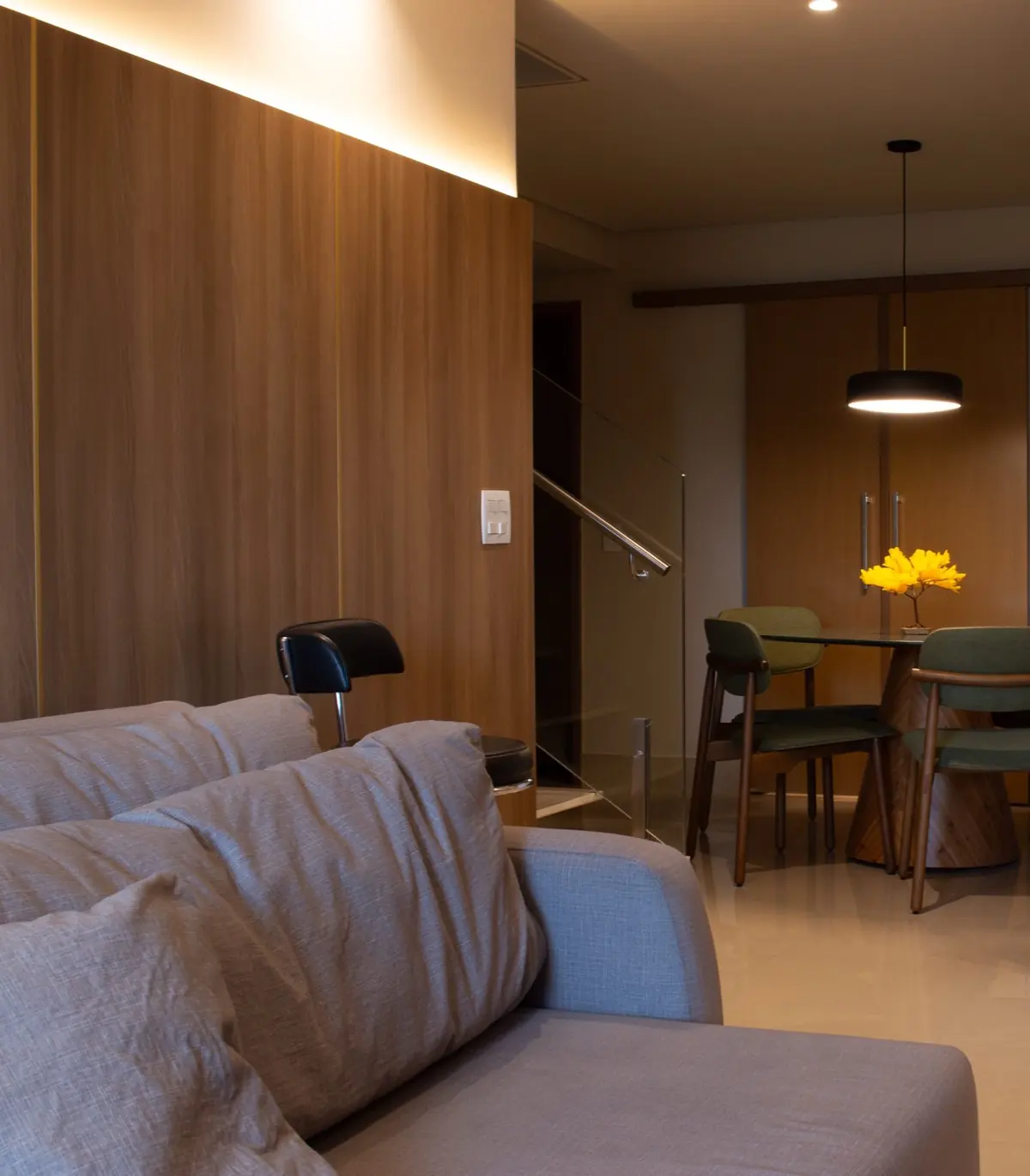 Living com painel de madeira, luz embutida e jantar integrado ao fundo