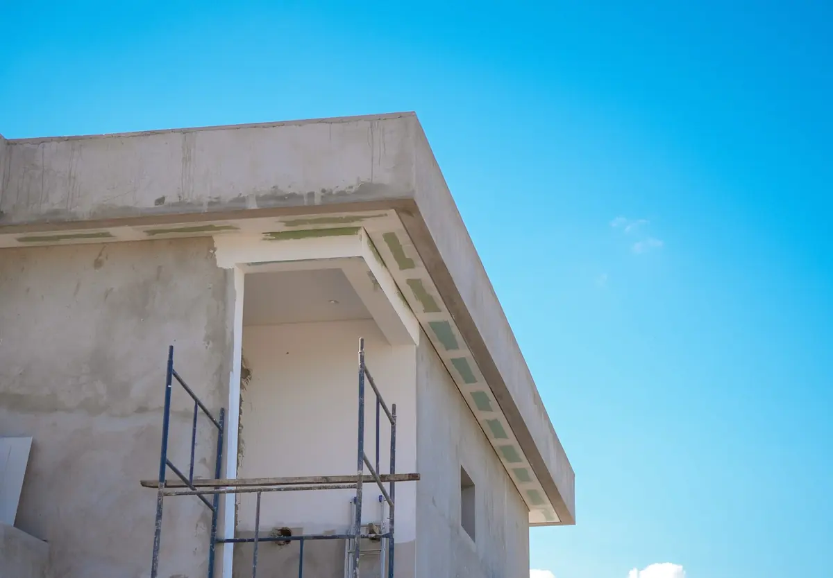 Residência em obra, com a laje concluída e andaimes na fachada